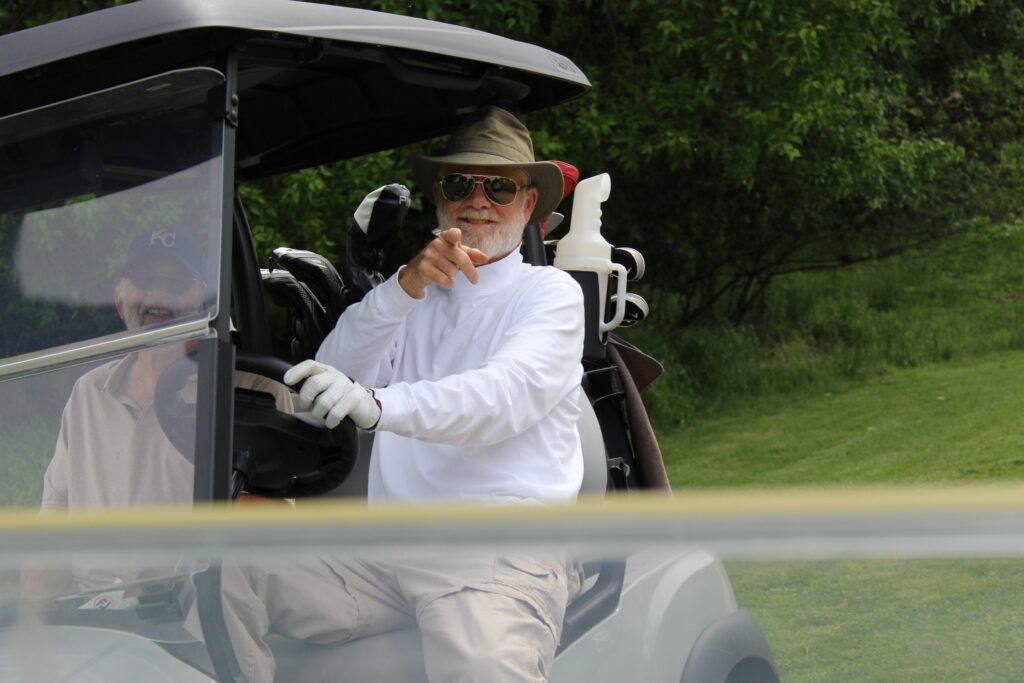 gold tournament - man pointing golf cart - amelia herbert - photo marketing